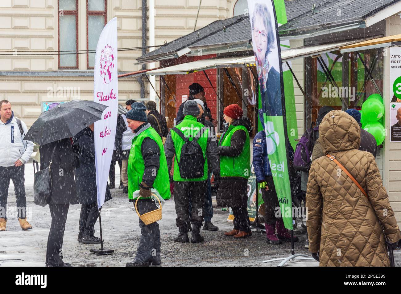 People at Keskustori square by the partie´s huts on first absentee voting day of the parliamentary election in rainy weather in Tampere Finland Stock Photo