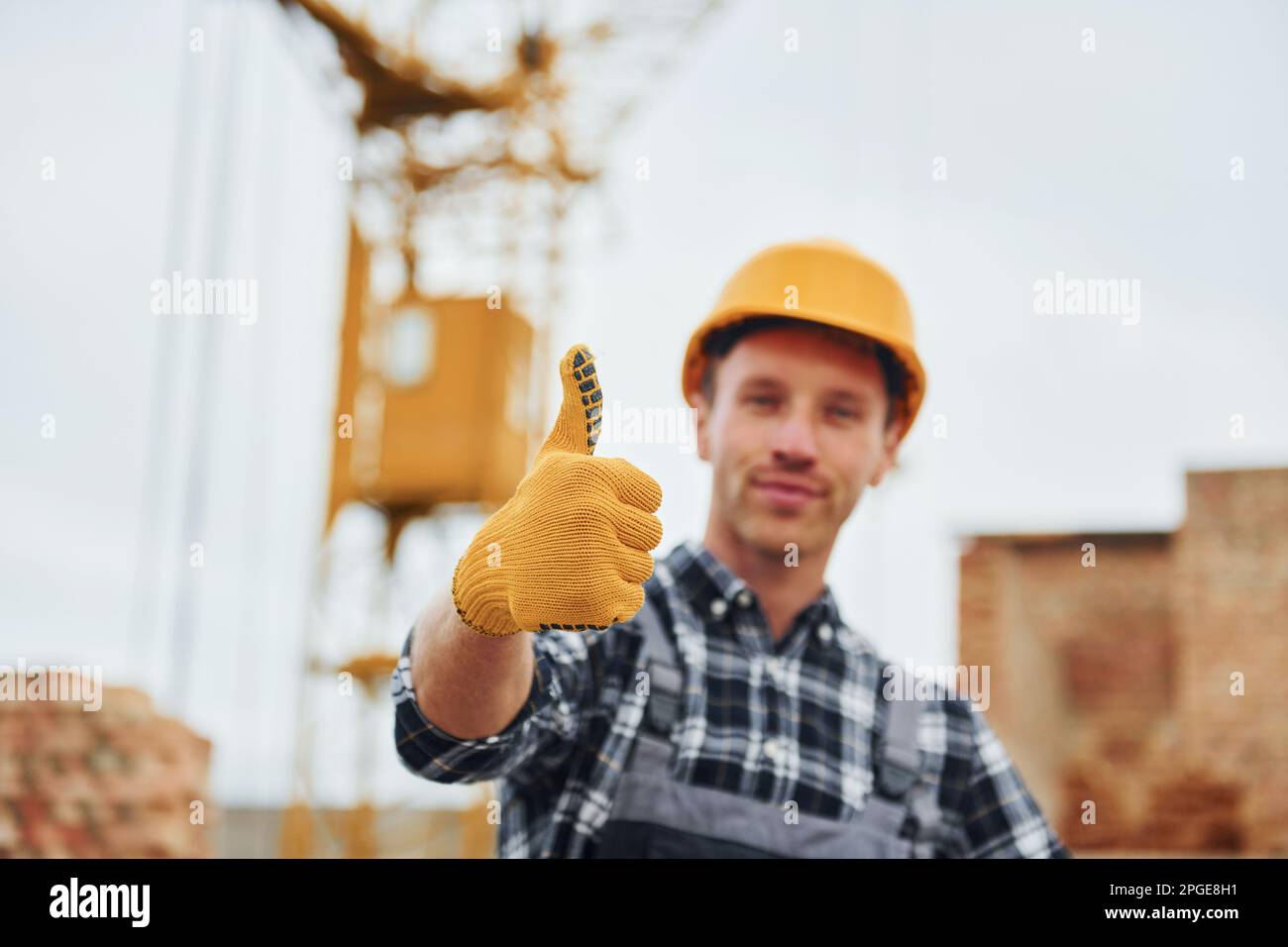 Shows thumb up. Construction worker in uniform and safety equipment ...