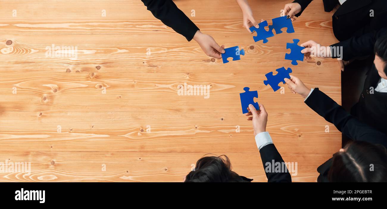 Top view businesspeople and colleagues in formal wear putting jigsaw