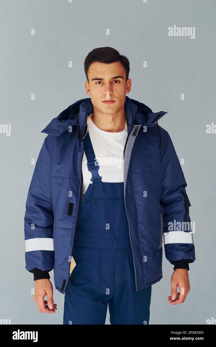 In Warm Jacket Male Worker In Blue Uniform Standing Inside Of Studio In Warm Jacket Male Worker In Blue Uniform Standing Inside Of Studio
