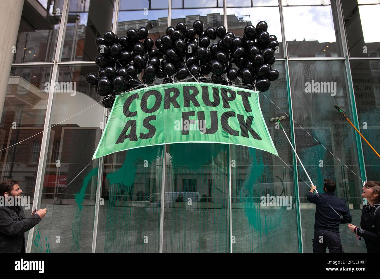 London, England, UK 22 March 2023. Protesters from Extinction Rebellion spray paint on the windows of News Corp, the headquarters of The Sun, in protest at their failure to report on the climate crisis. They held banners with the words 'Tell the Truth' and 'Corrupt as Fuck' emblazoned on them. This was part of a coordinated action where three mainstream news providers were targeted; The Sun, The Daily Mail and The Telegraph. Stock Photo