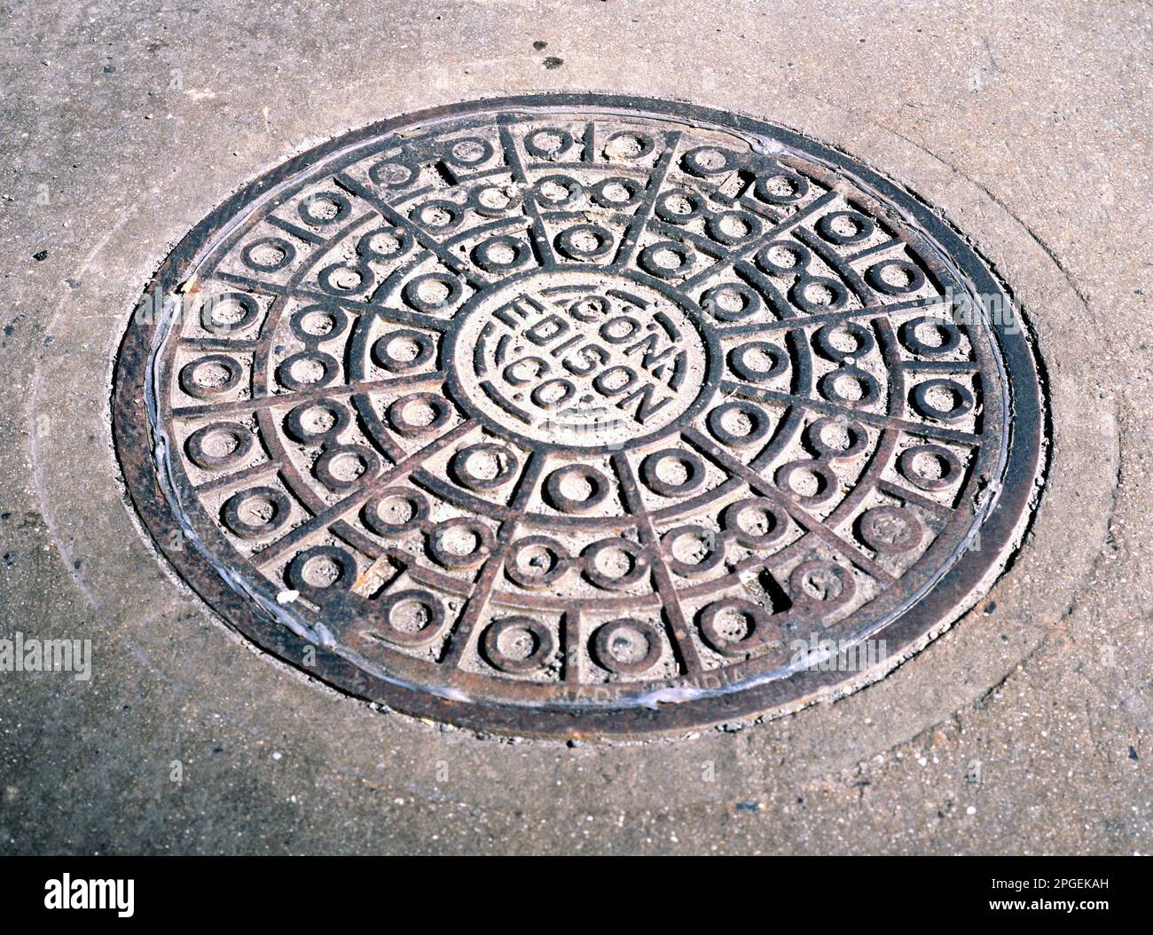 NEW YORK,USA-March 19, 2023: Manhole with metal cover in cracked asphalt surface at a street in New York city. Stock Photo