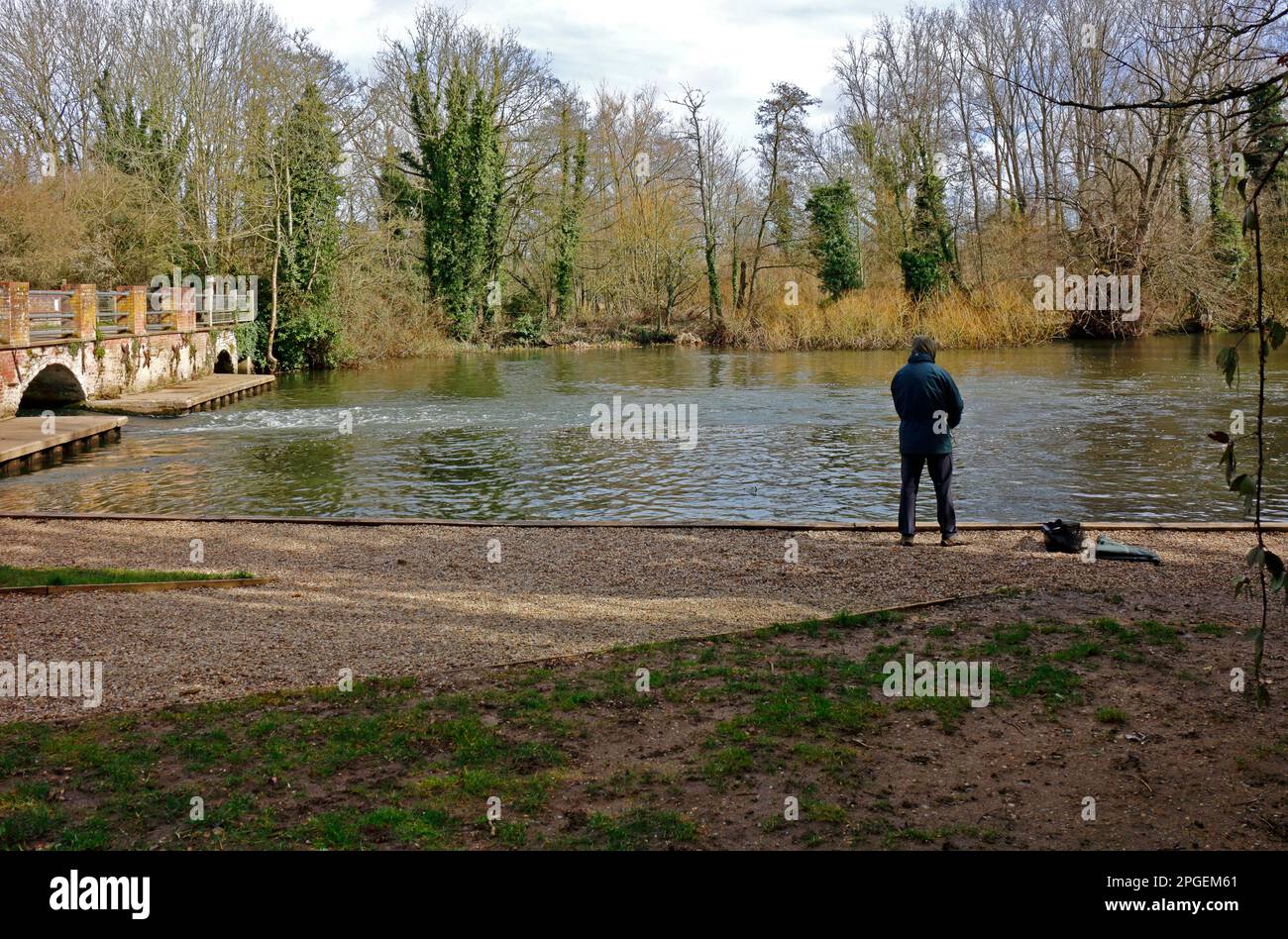 An angler fishing the mill pool by the remains of the old mill on the River Bure at Horstead, Norfolk, England, United Kingdom. Stock Photo