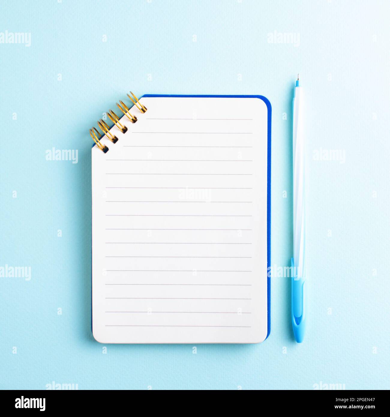 White binder blank notebook or diary or journal for writing text and  message with pencil on blue pastel wood background with copy space. Still  lifestyle photo concept. Stock Photo