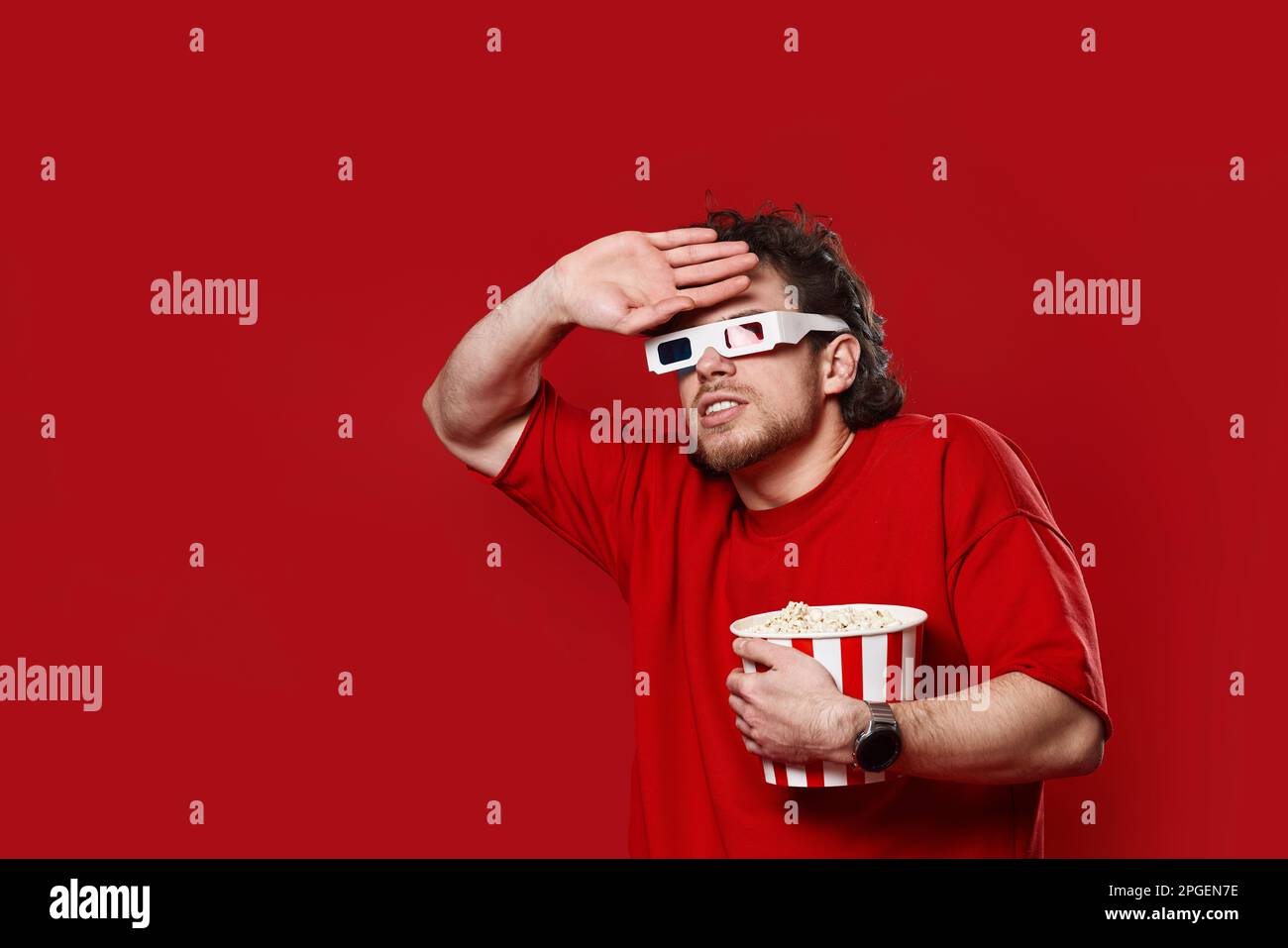 scared man in 3d-glasses holding bucket of popcorn Stock Photo