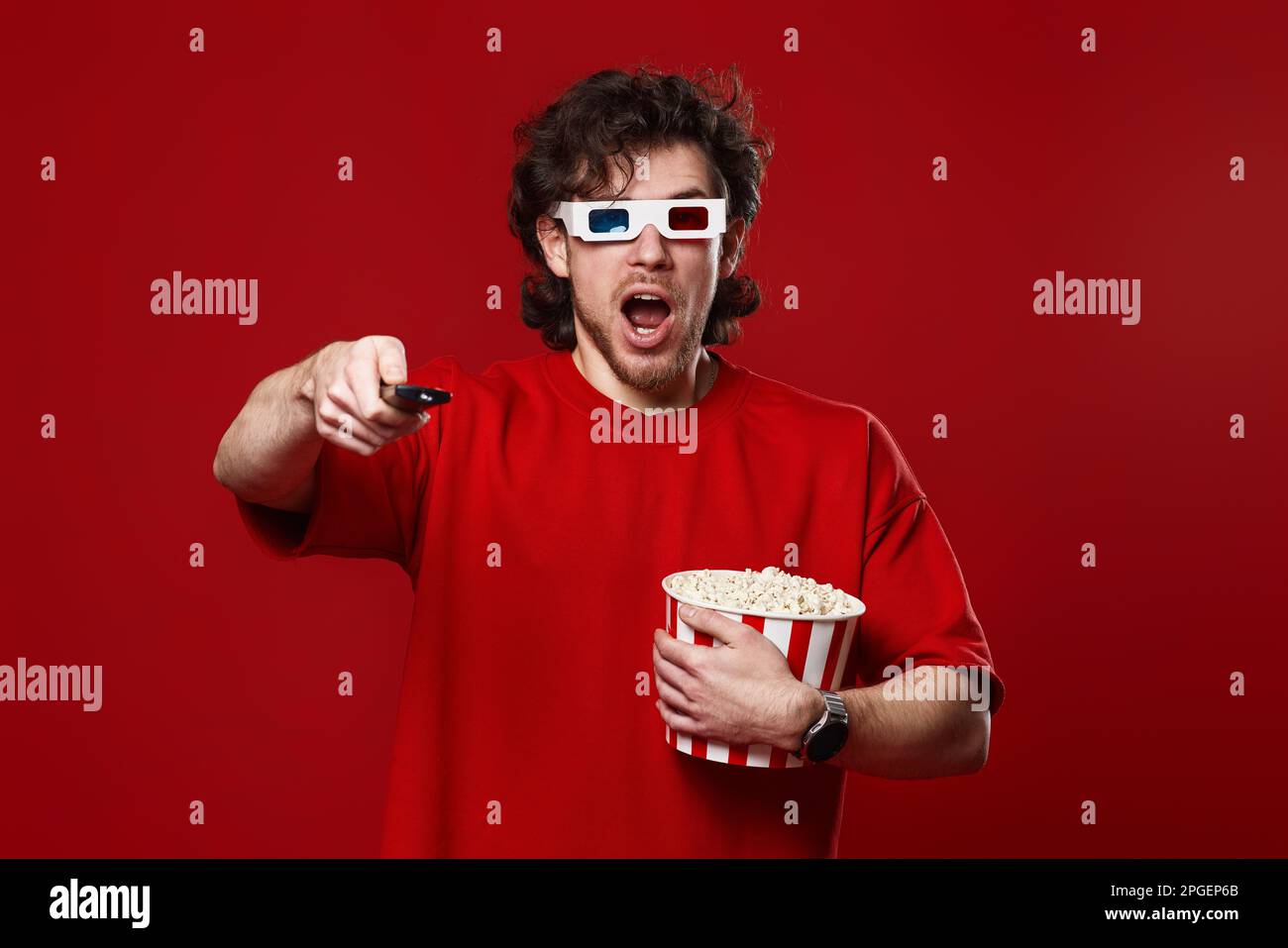 amazed shocked man in 3d glasses using remote controller Stock Photo