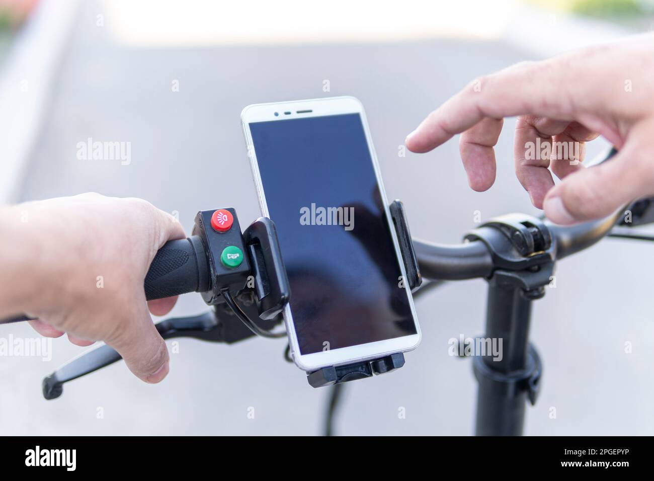 Man using a phone while riding a bike, image of dangerous bend as