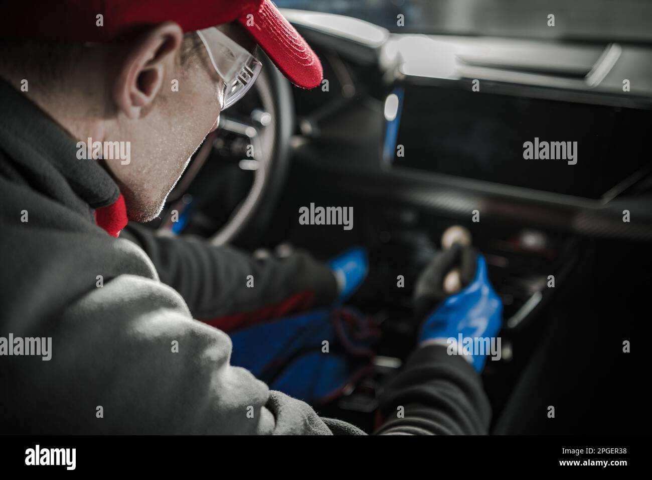 Caucasian Car Detailer Cleaning Modern Vehicle Dashboard. Automotive Industry Theme. Stock Photo