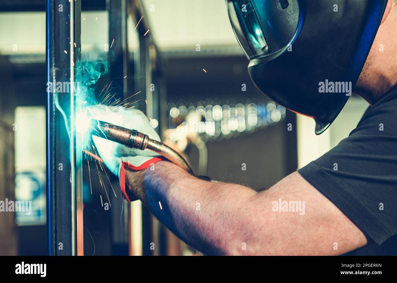 Professional Caucasian Welder Welding Large Metal Frame Pieces Together. Metalworking Industry. Stock Photo