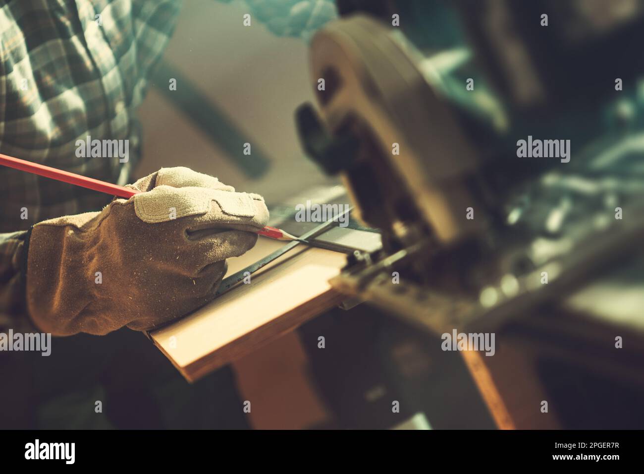 Man Measuring and Marking Piece of Wood Using Pencil To Cut Inside His Workshop. Close Up Photo. Stock Photo