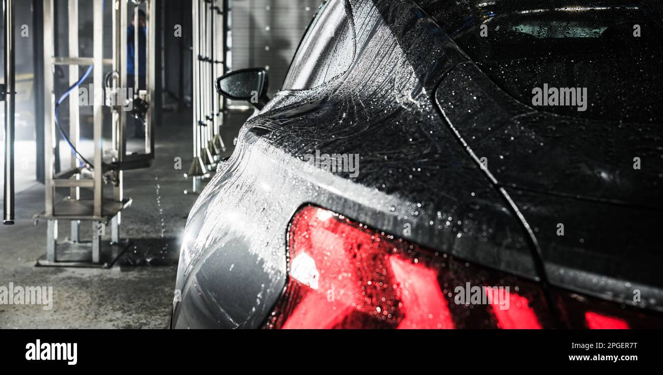 Modern Dark Grey Vehicle Inside a Touchless Car Wash Close Up. Transportation Theme. Stock Photo