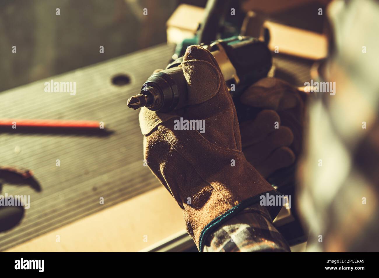 Construction Worker with Cordless Drill Driver and Wood Boring Drill Bit Attached Close Up Photo. Stock Photo