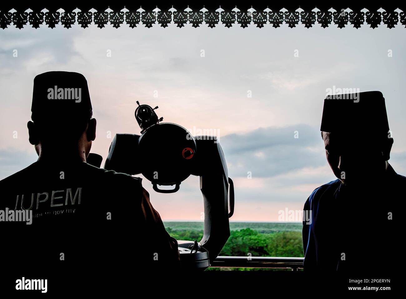 Silhouette of two officials from the Selangor Islamic Religious Council during a 'rukyah', a moon sighting ceremony to determine the start date of the holy month of Ramadan in Bukit Malawati. Stock Photo