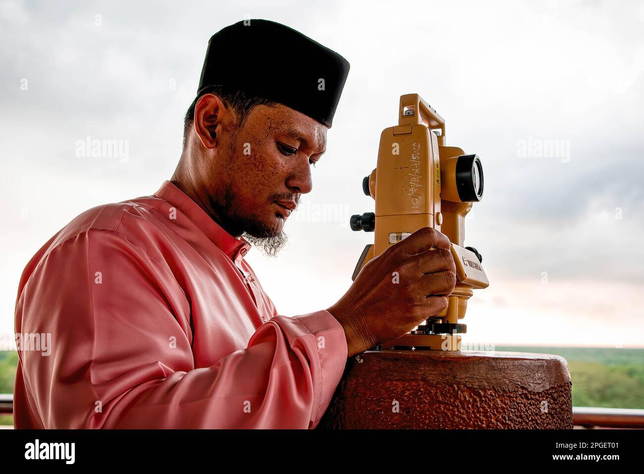 An official from the Selangor Islamic Religious Council is performing 'rukyah', a moon sighting ceremony to determine the start date of the holy month of Ramadan in Bukit Malawati. Stock Photo