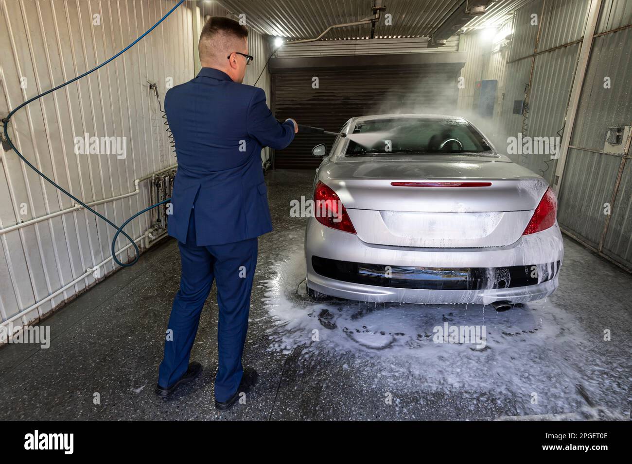 Male wash the car with high pressure washer. Car wash with foam in car