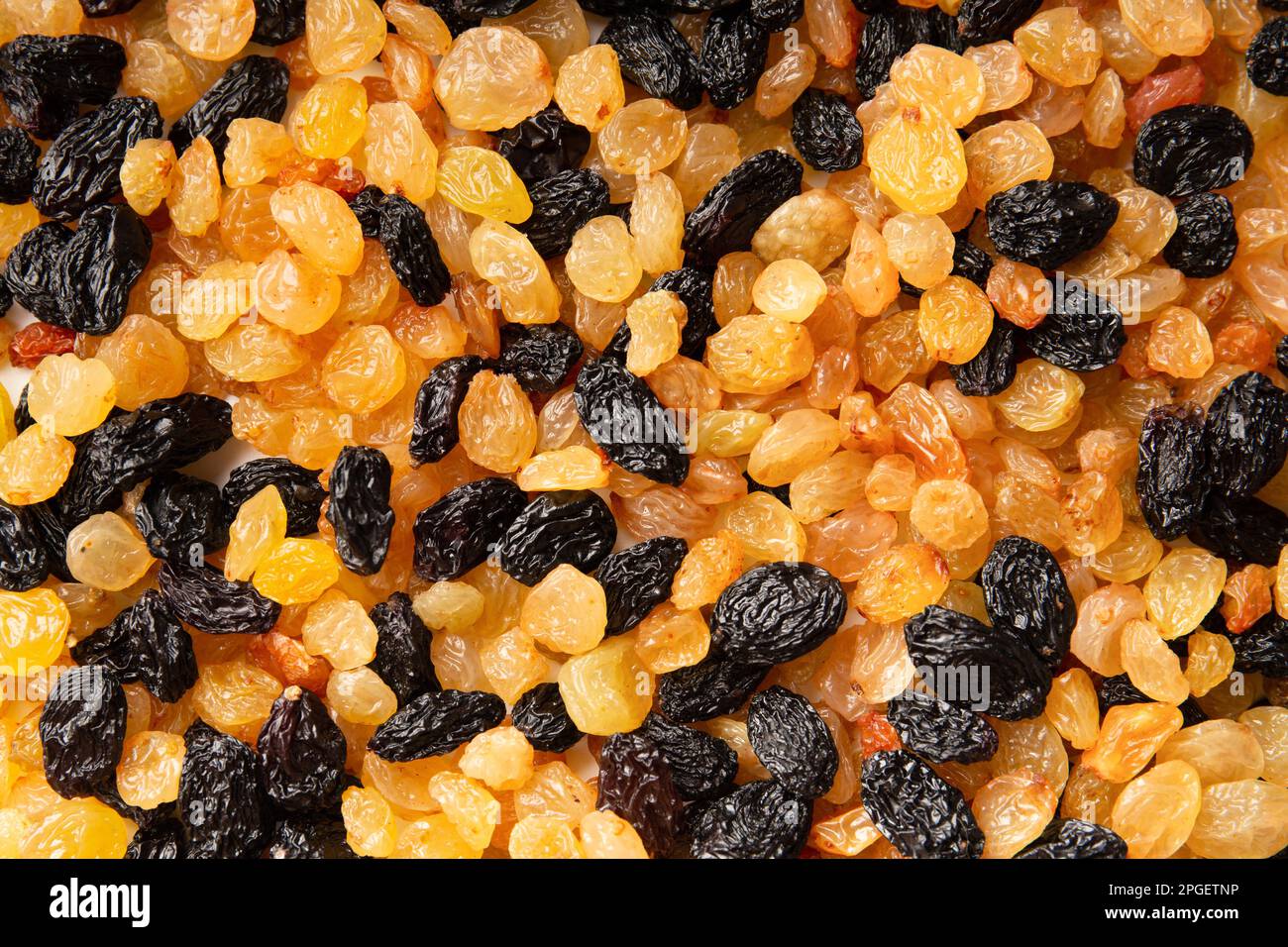 Light and dark raisins closeup top view. Dried grapes of different