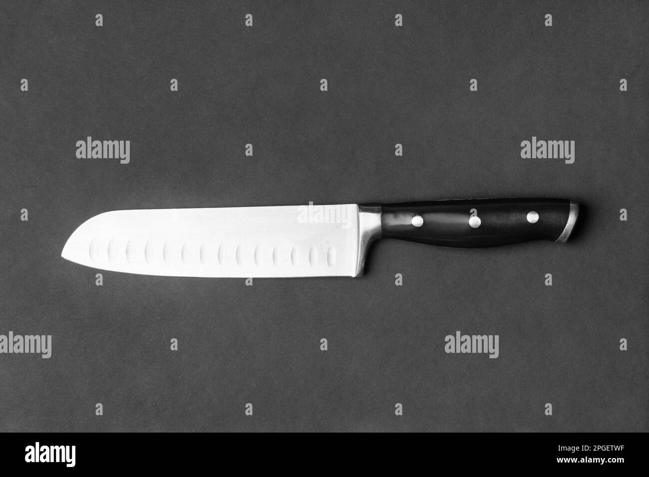 Kitchen knife with a black handle on a black background. Large knife on