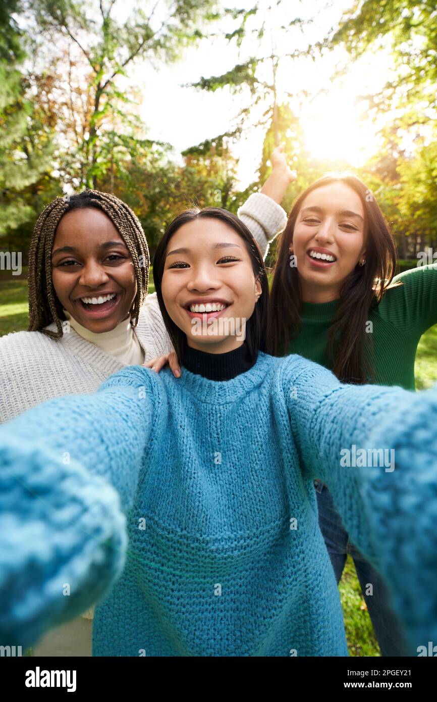 Vertical portrait smiling girls posing outdoor photo looking at camera. Multi-ethnic group people.  Stock Photo