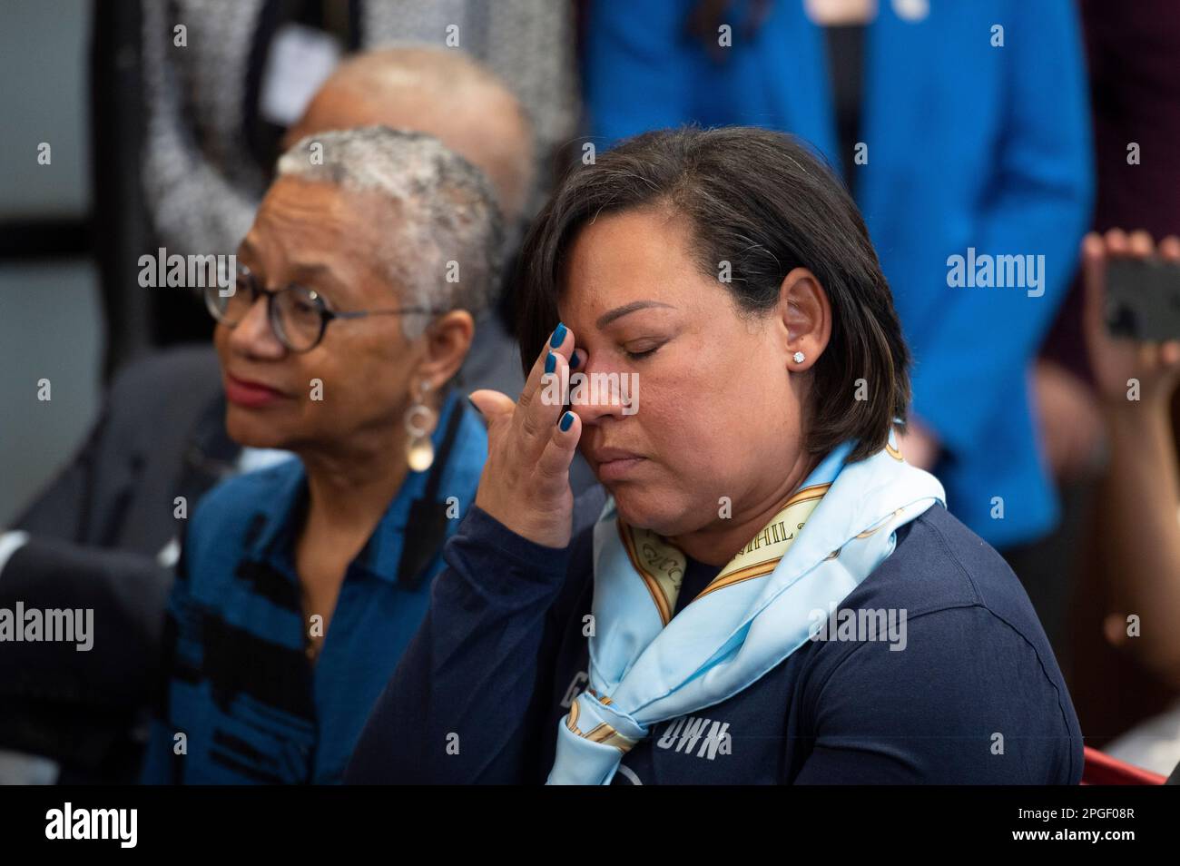 Nurys Cooley wipes tears as her husband, Ed Cooley, is introduced as