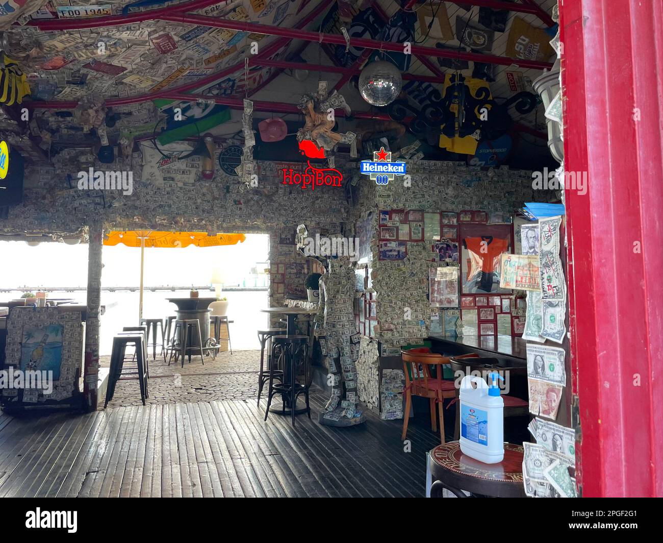 Oranjestad, Aruba - March 9, 2022. A bar completely wallpapered in paper money, mostly American dollar bills. Stock Photo