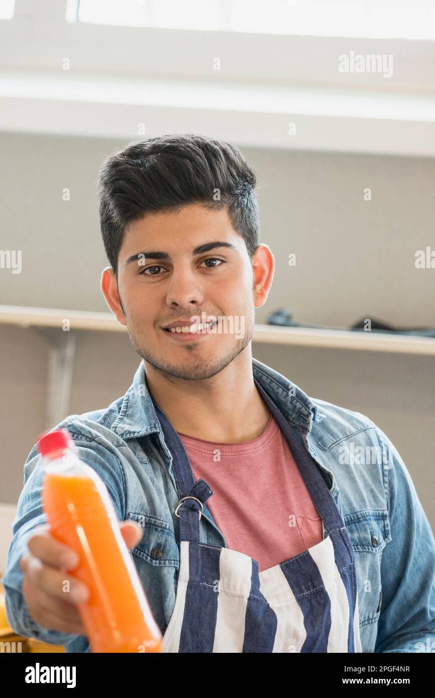 Man giving juice bottle in canteen School, Bavaria, Germany Stock Photo
