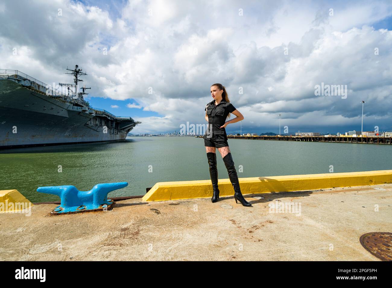 Goth Style Young Woman Standing in front of USS Hornet Stock Photo