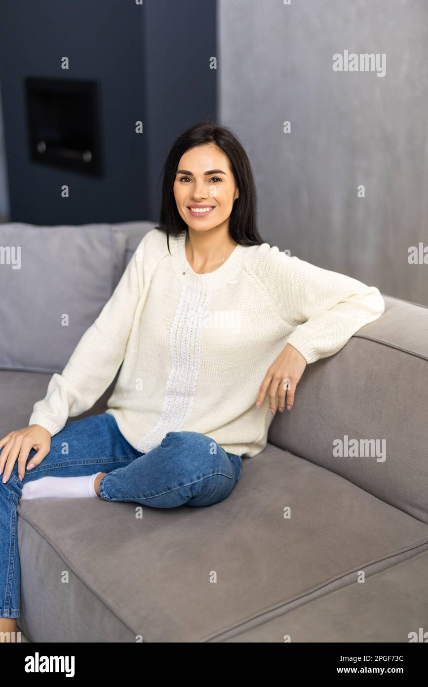 Beautiful woman with laptop resting on couch at home Stock Photo