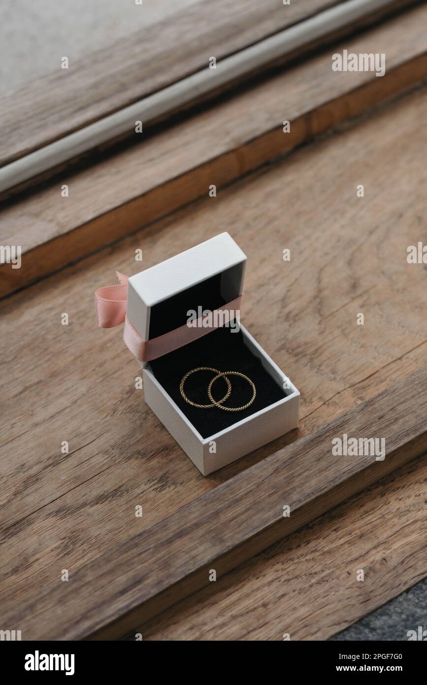 Golden wedding rings in ring box on wooden surface Stock Photo
