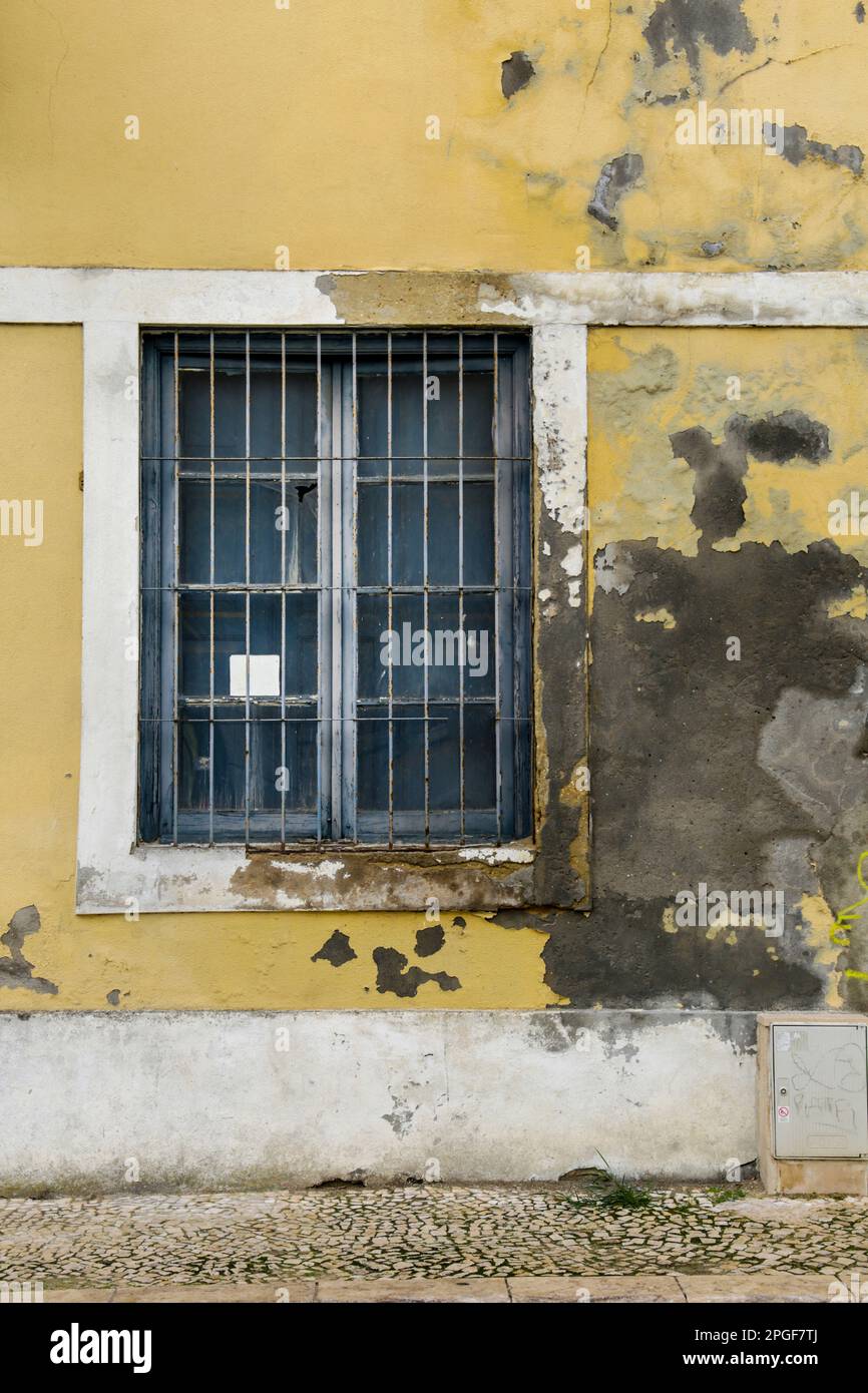 Old house with colorful chipped facade and gray metal window in Lisbon ...