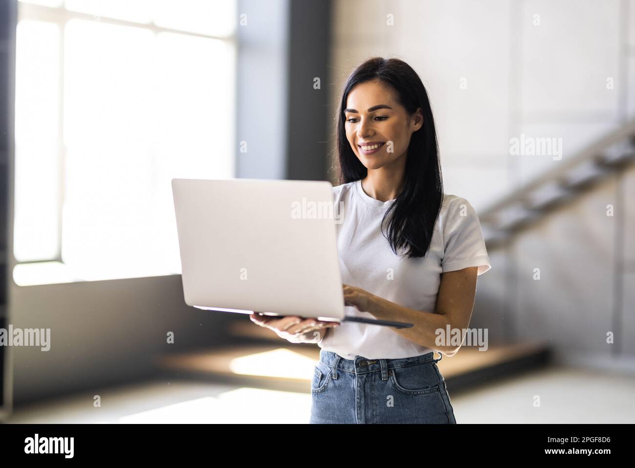 Beauitul young woman working using computer laptop concentrated and smiling Stock Photo