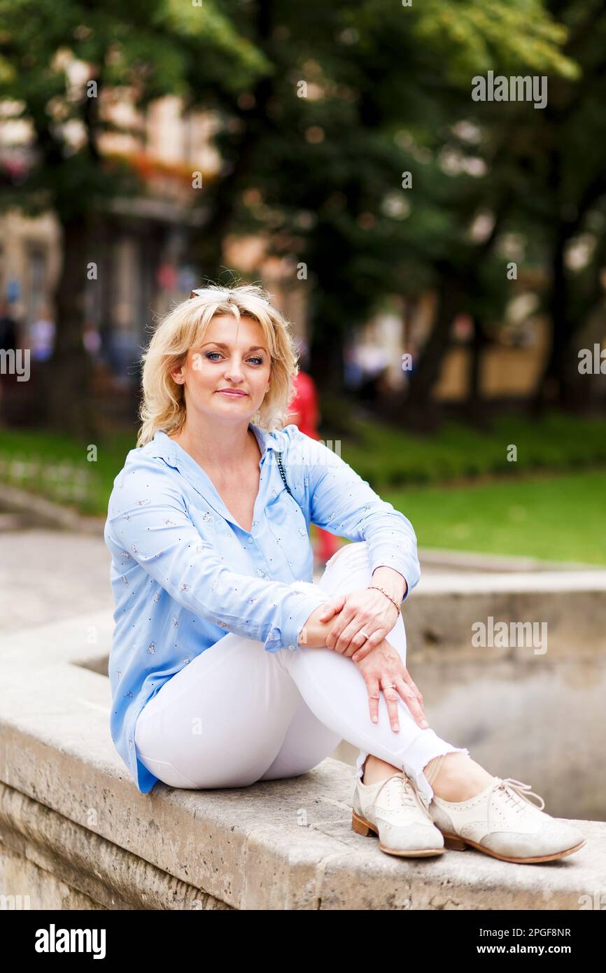 Charming woman sits on street hi-res stock photography and images - Alamy