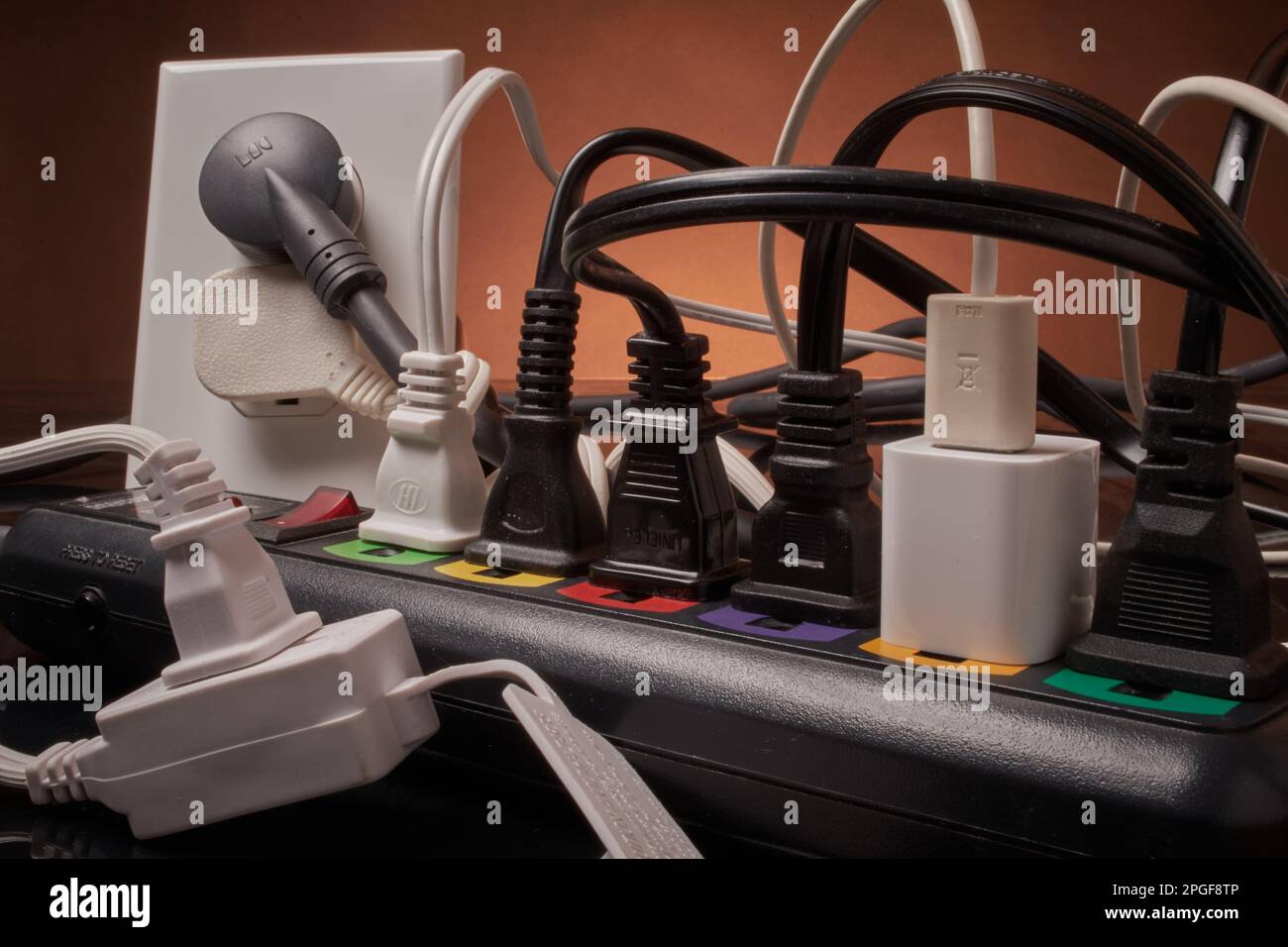 Electrical outlets and power strip overloaded beyond capacity Stock Photo