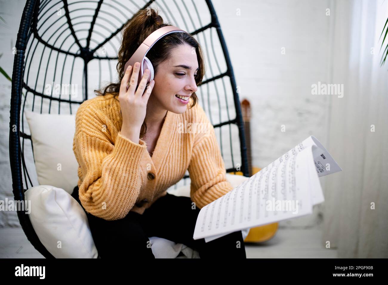 Young Woman with headphones composing music at home Stock Photo