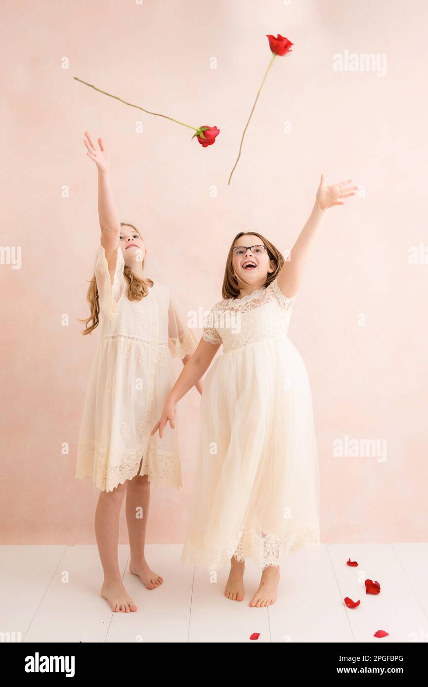 Two young girls throwing roses Stock Photo - Alamy