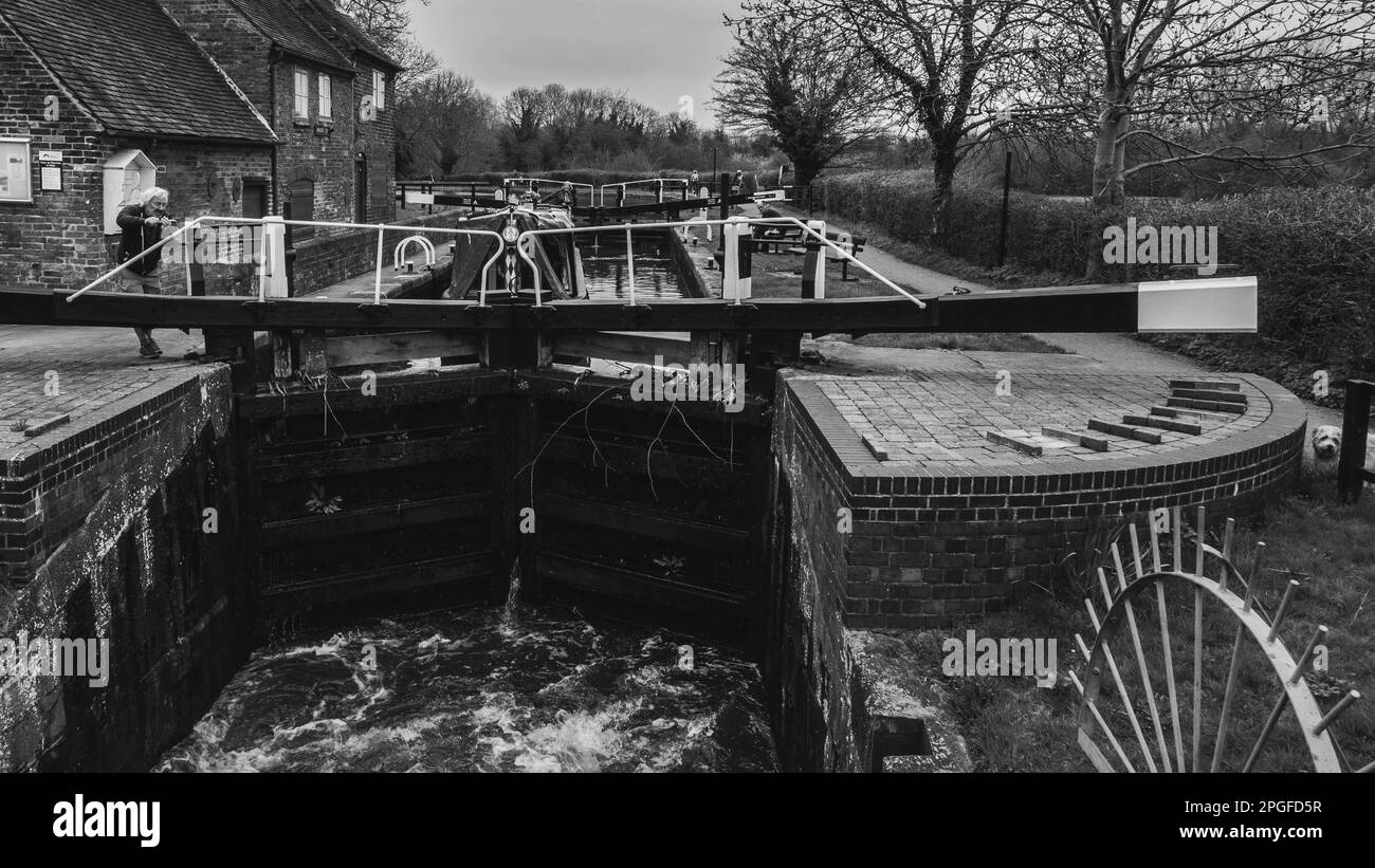 Black and white image of a couple going through a canal lock Stock Photo