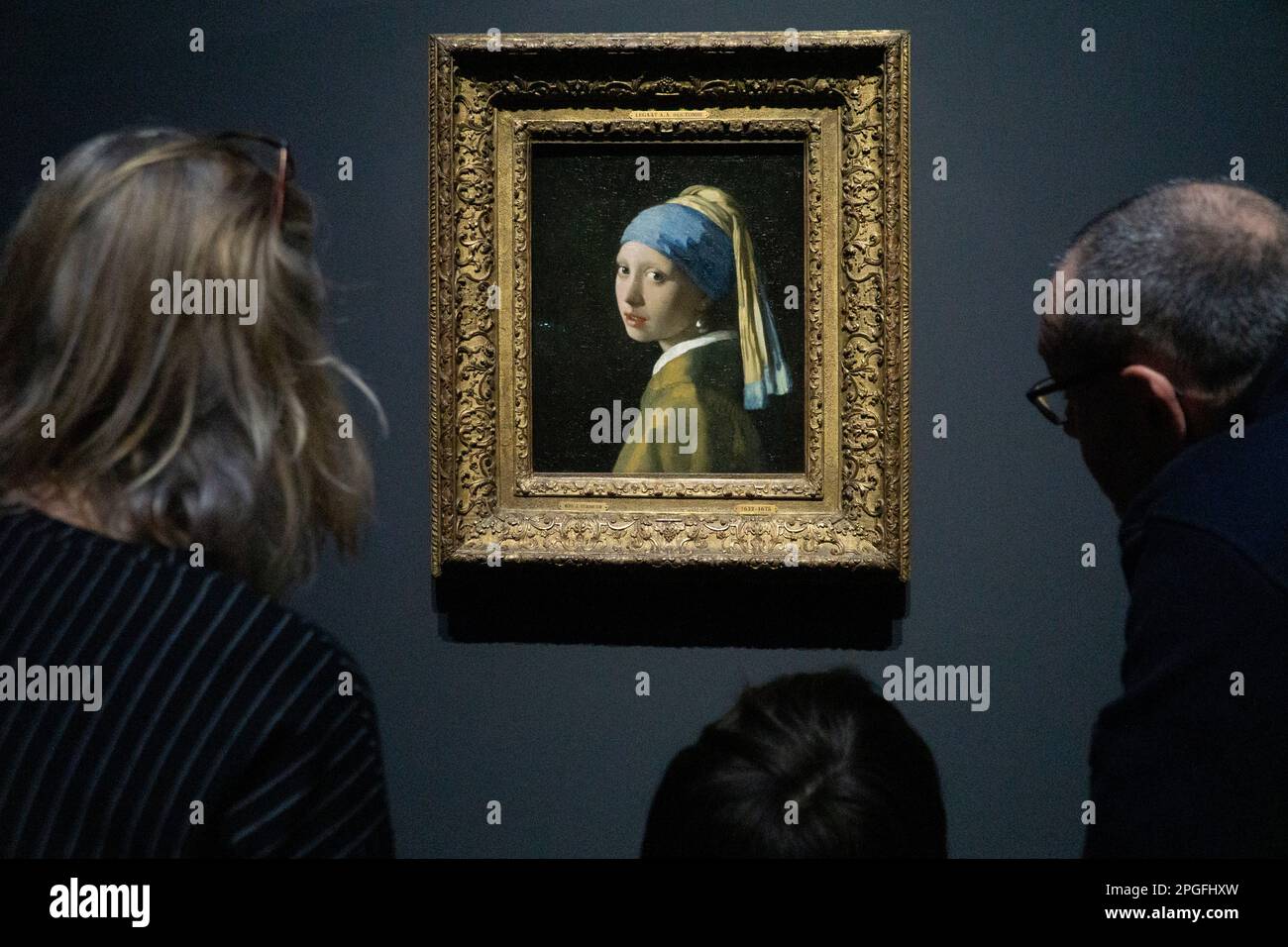 Amsterdam, The, Netherlands. 22nd Mar, 2023. Art lovers old and young crowd around Vermeer's painting 'Girl with a Pearl EArring' in the Rijksmuseum. Billed as a once in a lifetime bringing together of Vermeer's paintings from museums around the world, the show is totally sold out for it's entire run. Credit: Anna Watson/Alamy Live News Stock Photo