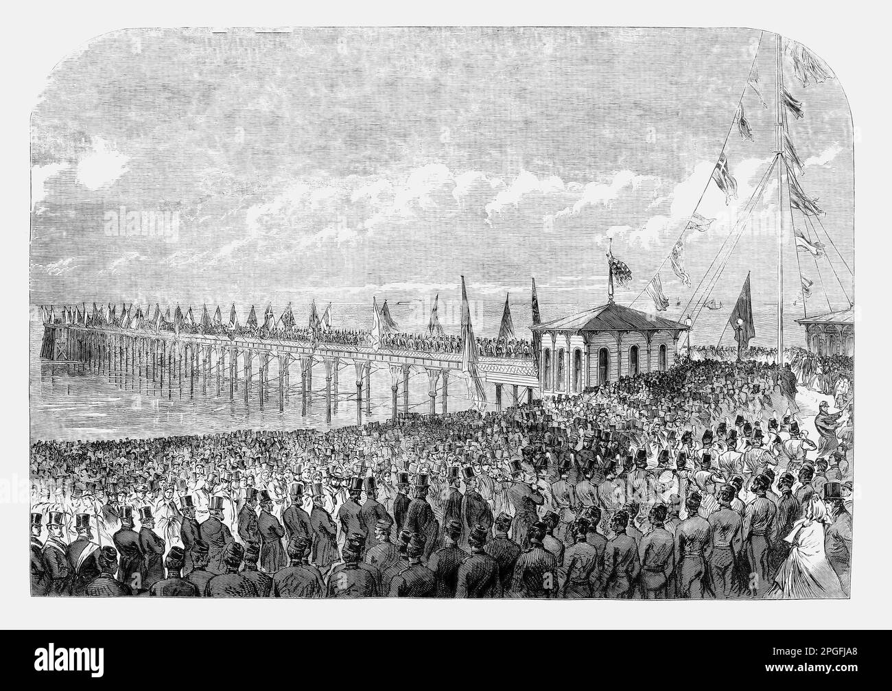 The opening of the new pier at Deal, Kent, England, in 1864. A second 1,100 feet (340 m) long pier designed by Eugenius Birch opened, with extensions in 1870 adding a reading room and a pavilion in 1886. It sustained impact damage several times during the 1870s and was acquired by Deal Council in 1920. A popular pleasure pier, it survived until the Second World War, when it was struck and severely damaged by a mined Dutch ship, the Nora, in January 1940. Stock Photo