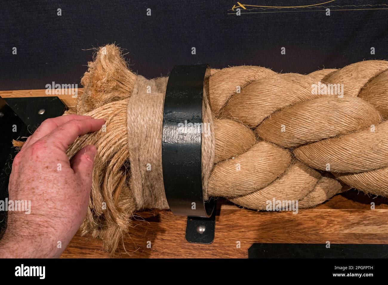 A section of completed rope (with a hand for scale) on display in the Ropery Gallery, Historic Dockyard Chatham, Kent, UK. Stock Photo