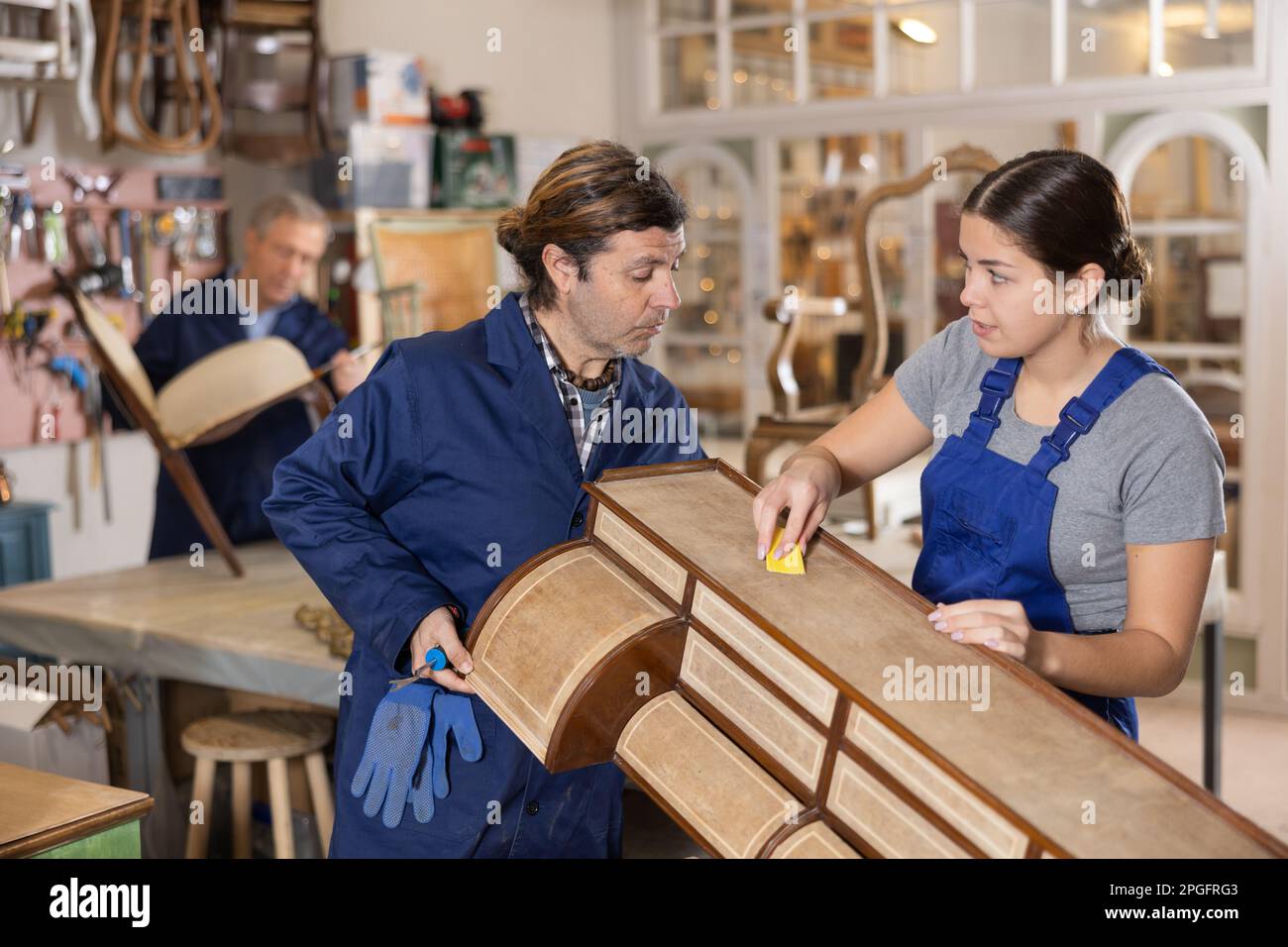 Professional male and female artisans restorers in uniform renovating