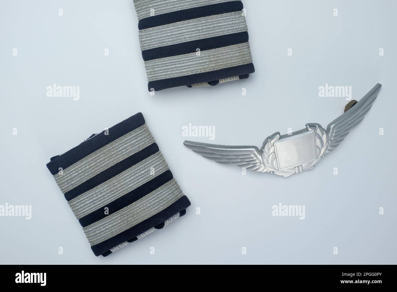 Helsinki / Finland - MARCH 23, 2023, Flatlay closeup of first officer epaulets and an aviator badge. Stock Photo
