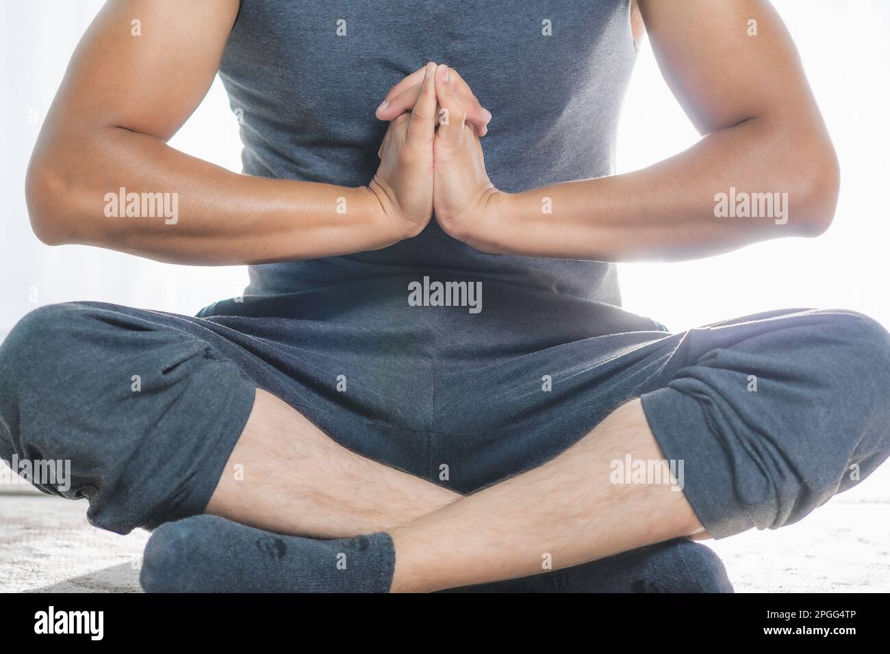 Man does Yoga indoors, approach, does deep meditation postures. It is very quiet. Stock Photo