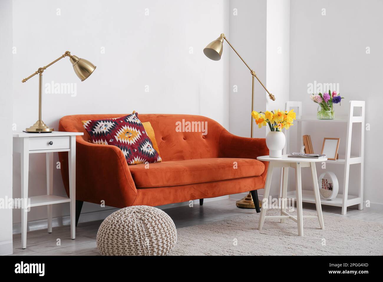 Interior of stylish living room with cozy sofa, coffee table and lamps ...