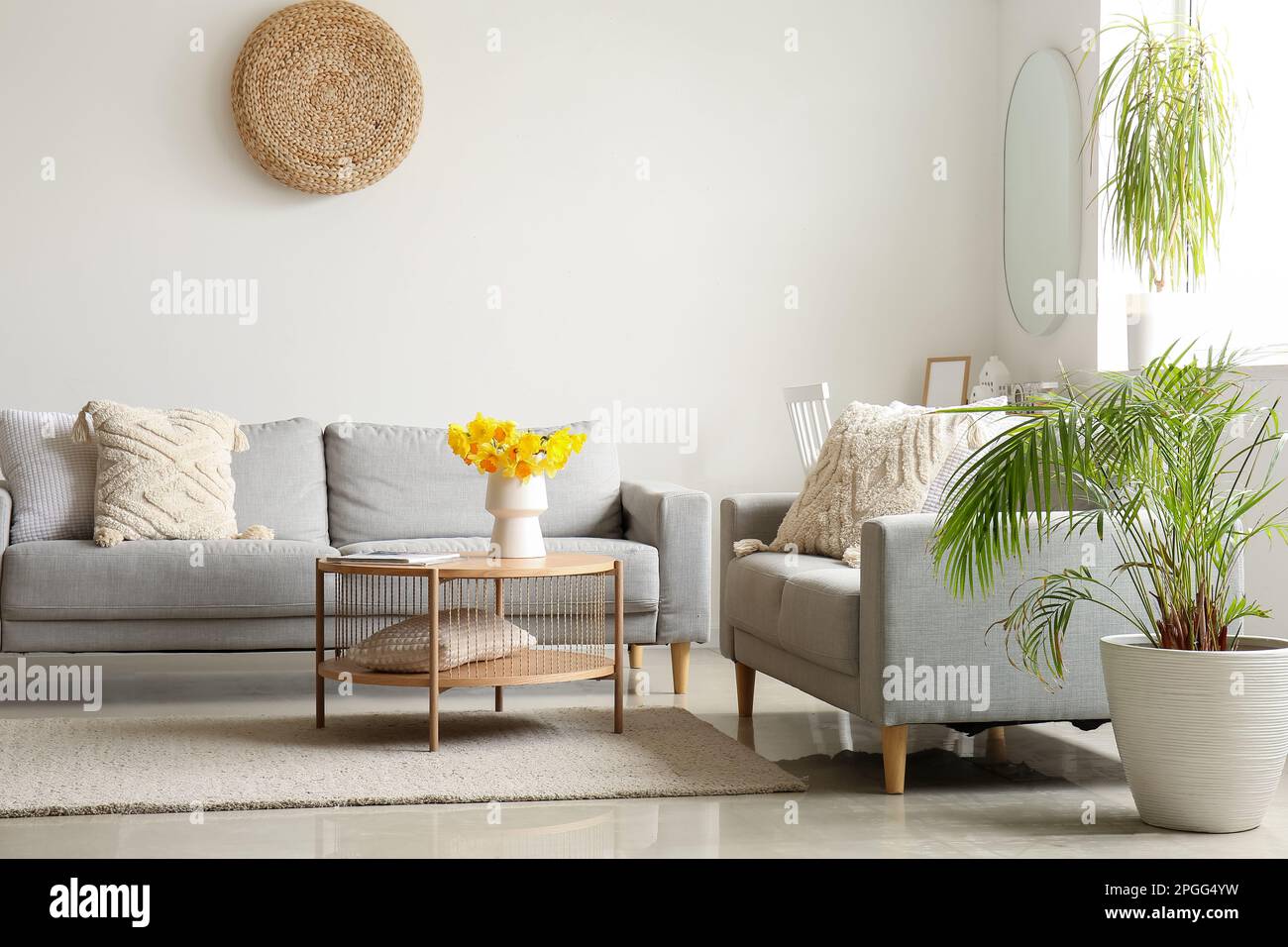 Interior of modern living room with cozy sofas and flower vase on