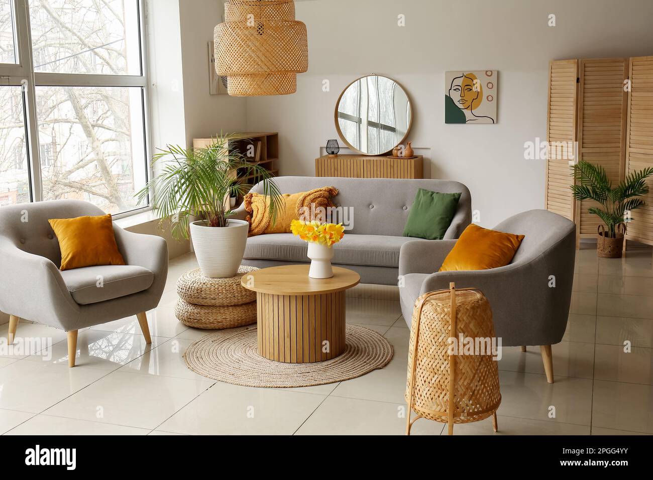 Interior of cozy living room with sofa, armchairs and flower vase on ...