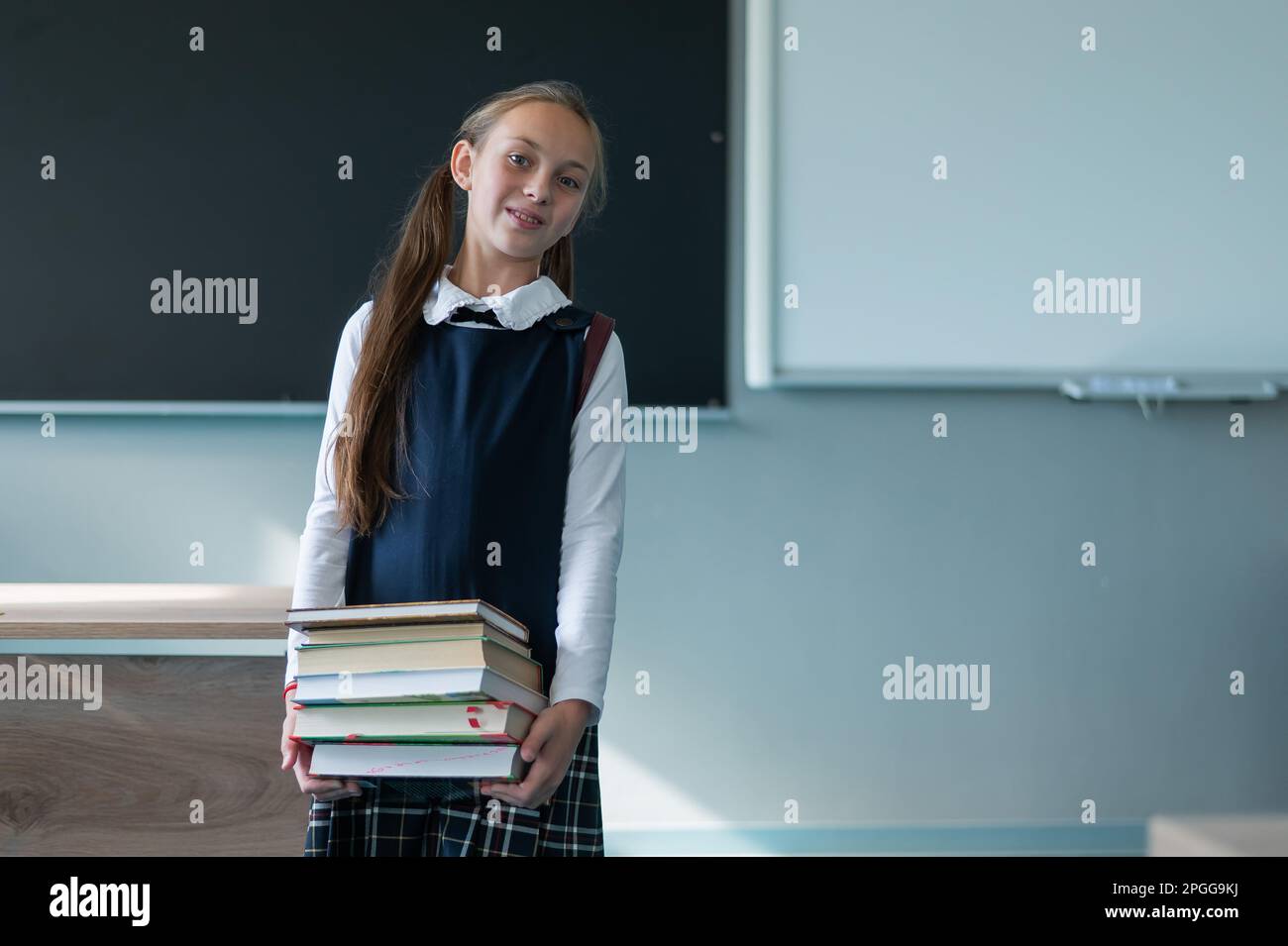 Portrait of a caucasian schoolgirl with a backpack. The girl is holding ...