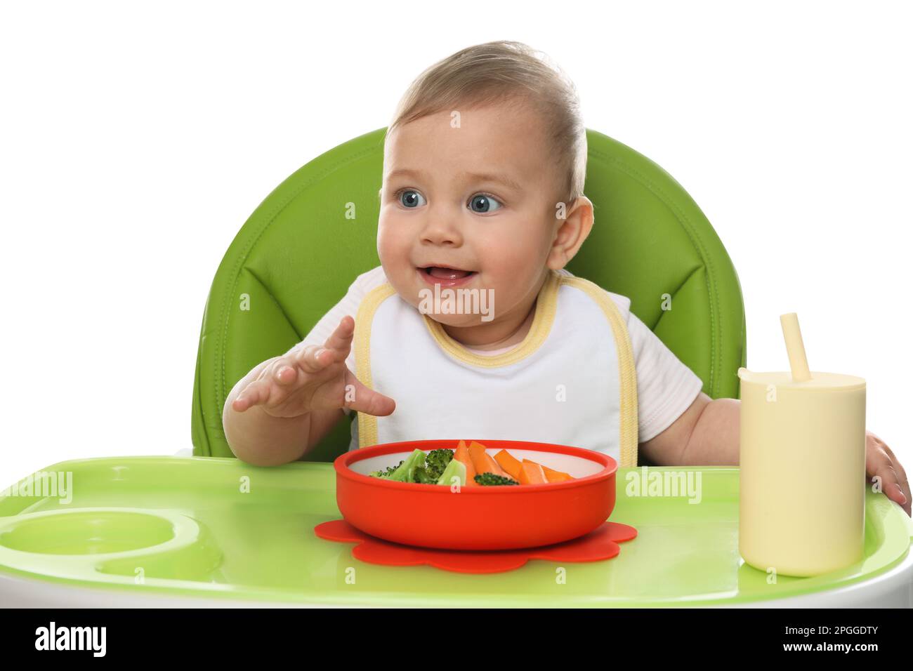 Cute little baby wearing bib while eating on white background Stock Photo Alamy
