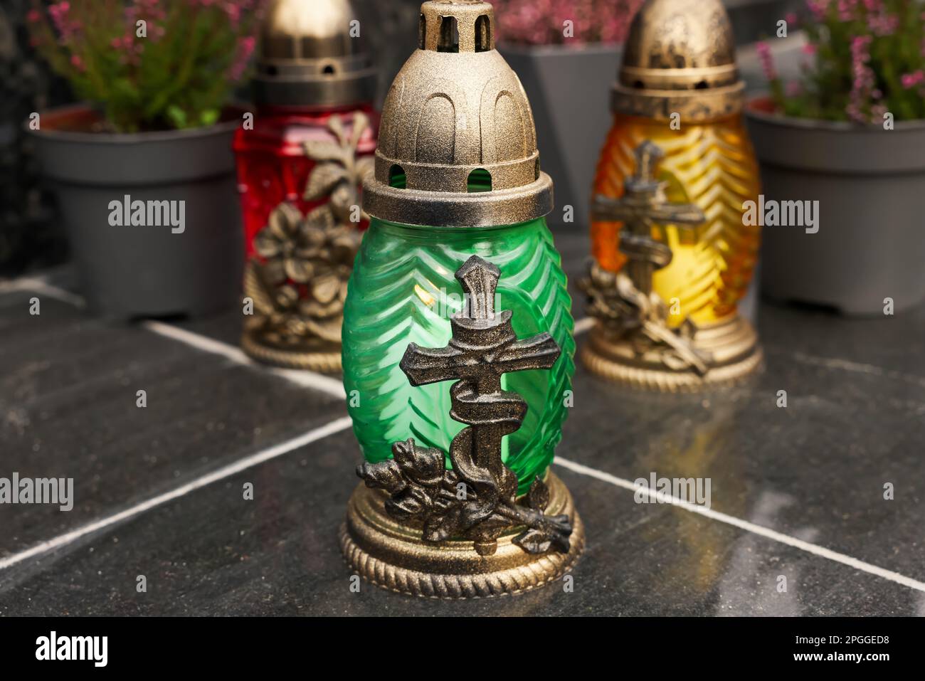 Different grave lanterns on black tiled surface outdoors Stock Photo