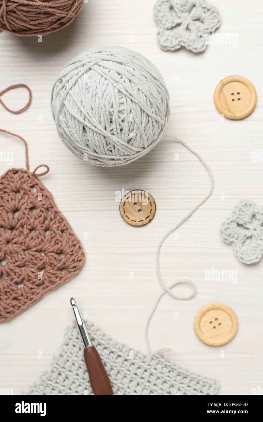 Flat lay composition with knitting threads and crochet hook on white wooden table Stock Photo