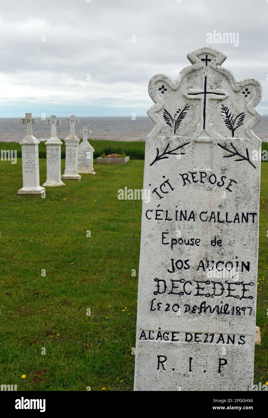 Headstones dating from the 19th Century in the Acadian seaside cemetery at the Notre Dame du Mont Carmel church at Mont Carmel, Prince Edward Island. Stock Photo