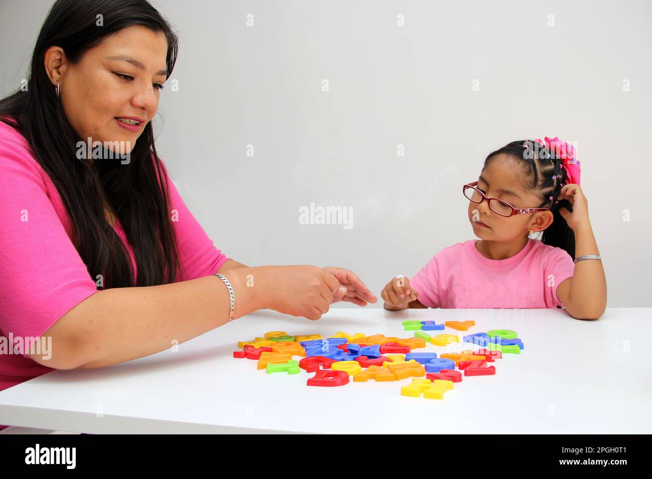 4-year-old Latina girl takes child therapy with the psychotherapist through games to treat her atuism and reflects emotions to learn Stock Photo